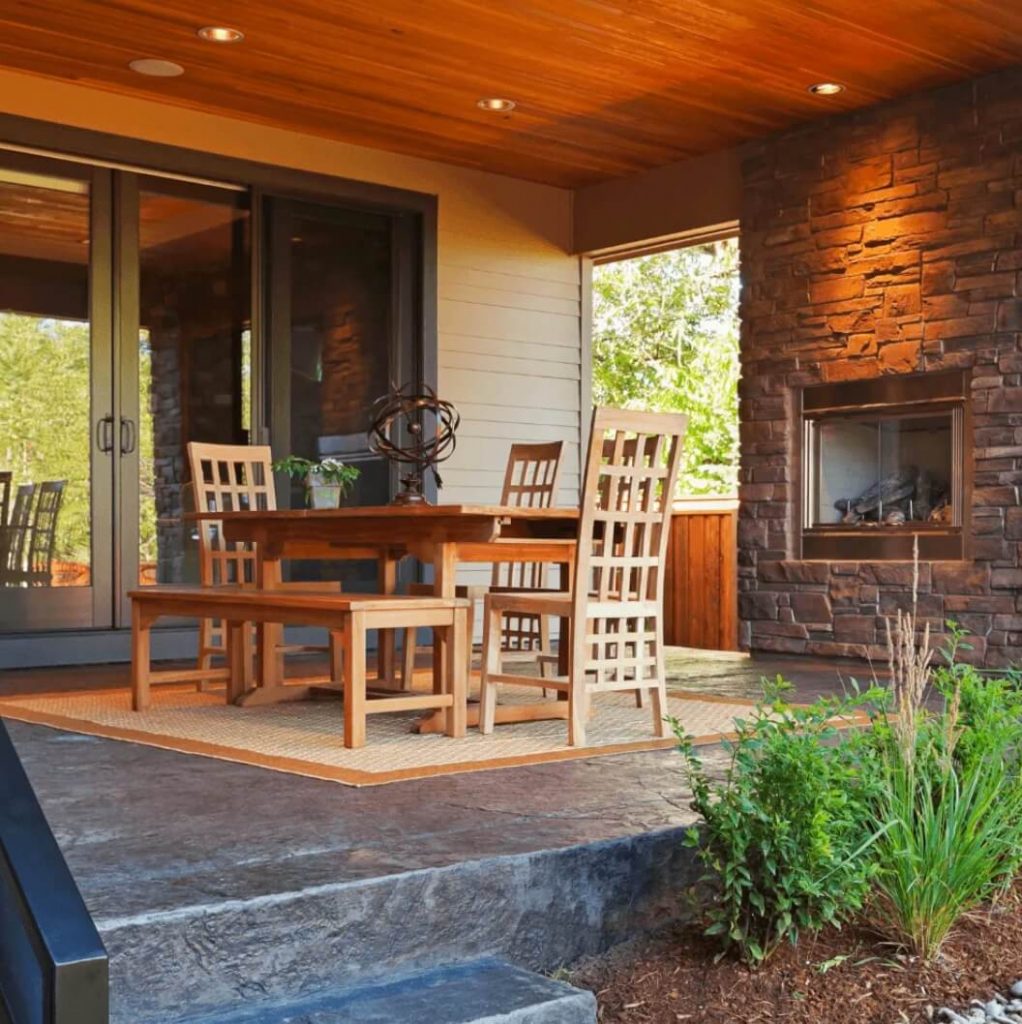 Modern themed patio with custom wood furniture and brick fireplace made by Newton MA Home Remodeling Exponential Construction Corp.