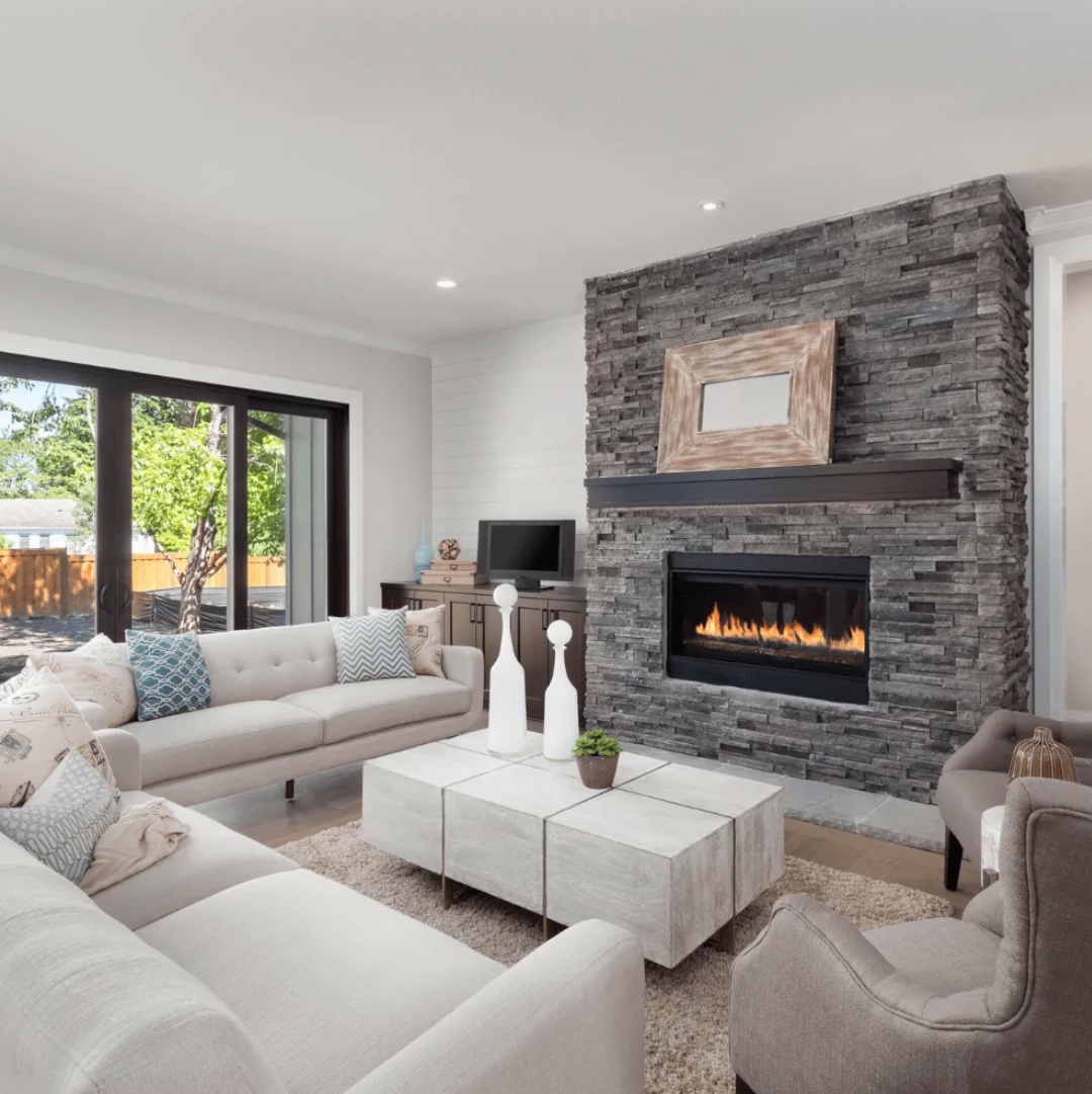 Spacious living room with large brick fireplace and white couches - Newton MA Home Remodeling Exponential Construction Corp.